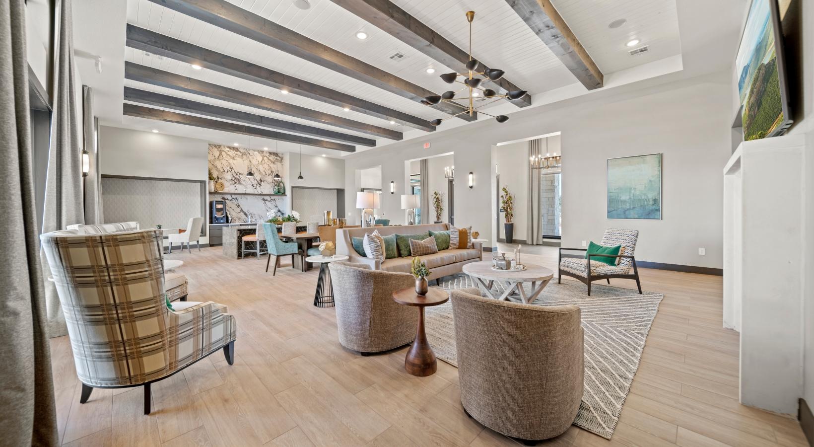 Settle into comfort at Emerson at Wells Branch a large living room with a wood floor and a chandelier